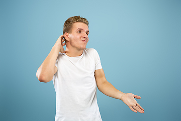 Image showing Caucasian young man\'s half-length portrait on blue background