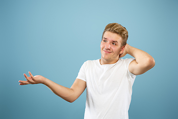 Image showing Caucasian young man\'s half-length portrait on blue background