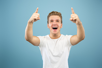 Image showing Caucasian young man\'s half-length portrait on blue background