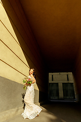 Image showing Caucasian romantic young groom celebrating his marriage in city