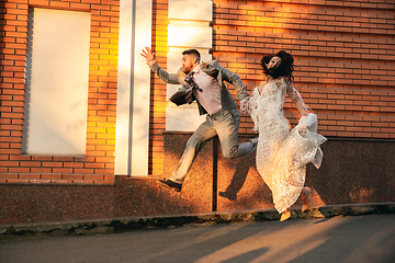Image showing Caucasian romantic young couple celebrating their marriage in city