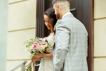 Image showing Caucasian romantic young couple celebrating their marriage in city