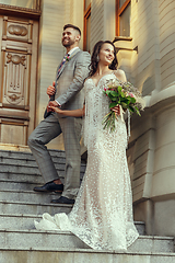 Image showing Caucasian romantic young couple celebrating their marriage in city