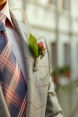 Image showing Caucasian romantic young groom celebrating his marriage in city