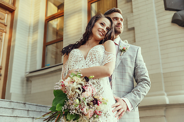 Image showing Caucasian romantic young couple celebrating their marriage in city