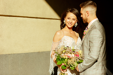 Image showing Caucasian romantic young couple celebrating their marriage in city