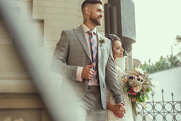 Image showing Caucasian romantic young couple celebrating their marriage in city