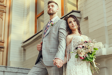 Image showing Caucasian romantic young couple celebrating their marriage in city