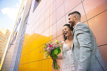Image showing Caucasian romantic young couple celebrating their marriage in city