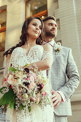 Image showing Caucasian romantic young couple celebrating their marriage in city