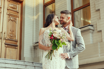 Image showing Caucasian romantic young couple celebrating their marriage in city