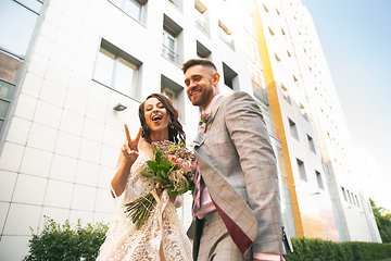 Image showing Caucasian romantic young couple celebrating their marriage in city