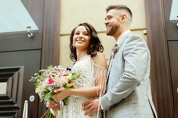 Image showing Caucasian romantic young couple celebrating their marriage in city