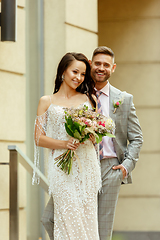 Image showing Caucasian romantic young couple celebrating their marriage in city