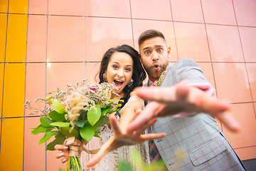 Image showing Caucasian romantic young couple celebrating their marriage in city