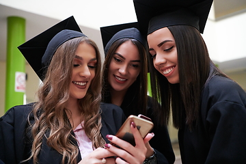 Image showing students in mortar boards using smartphone