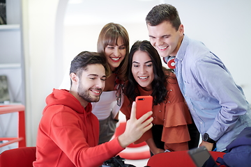 Image showing Group of multiethnic teenagers taking a selfie in schoolthe student uses a notebook and a school library