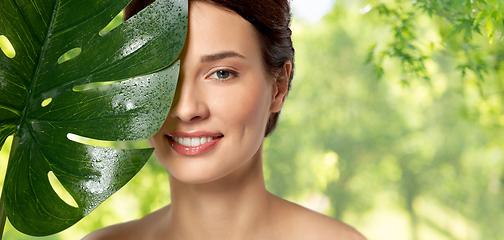 Image showing beautiful young woman with green monstera leaf