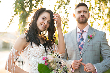 Image showing Caucasian romantic young couple celebrating their marriage in city