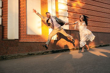 Image showing Caucasian romantic young couple celebrating their marriage in city