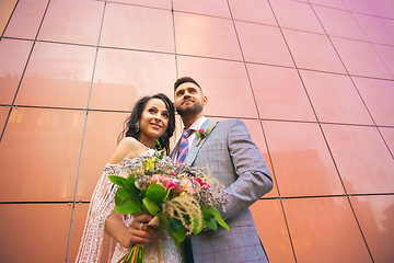 Image showing Caucasian romantic young couple celebrating their marriage in city