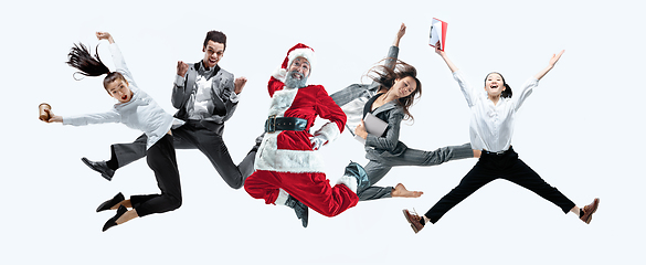 Image showing Happy Christmas Santa Claus jumping on studio background