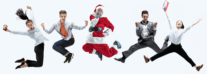 Image showing Happy Christmas Santa Claus jumping on studio background