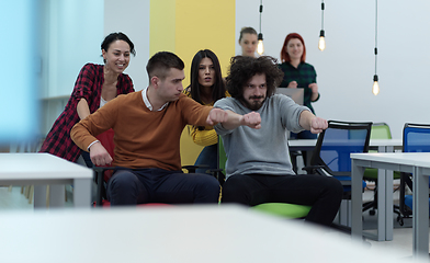 Image showing Multiethnic startup group at office chair race