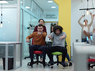 Image showing Multiethnic startup group at office chair race