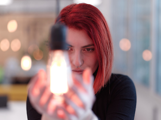 Image showing businesswoman holding hand around light bulb