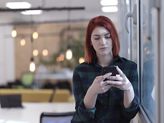 Image showing redhead business woman at office using smart phone