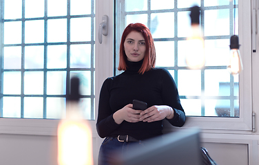 Image showing redhead business woman at office using smart phone