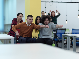 Image showing Multiethnic startup group at office chair race