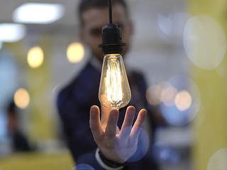 Image showing businessman holding hand around light bulb