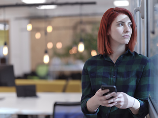 Image showing redhead business woman at office using smart phone