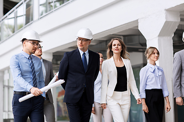 Image showing business team in helmets walking along office