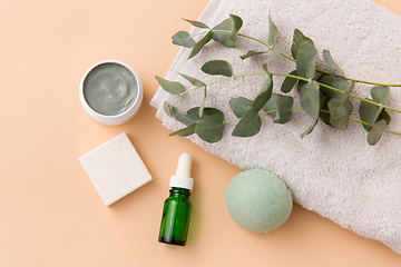 Image showing serum, clay mask, oil and eucalyptus on bath towel