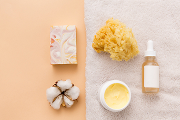 Image showing body butter, essential oil, sponge on bath towel