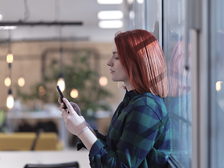 Image showing redhead business woman at office using smart phone