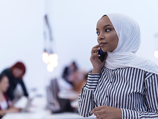 Image showing African muslim businesswoman at office using smart phone