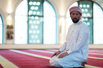 Image showing a Muslim ends a prayer by turning his head to the side,.