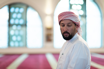 Image showing a Muslim ends a prayer by turning his head to the side,.