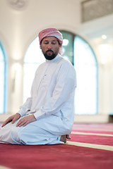 Image showing a Muslim ends a prayer by turning his head to the side,.