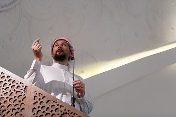 Image showing Muslims young arabic Imam has a speech on friday afternoon prayer in mosque.