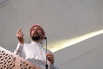 Image showing Muslims young arabic Imam has a speech on friday afternoon prayer in mosque.