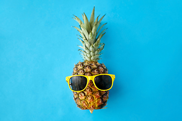 Image showing pineapple in yellow sunglasses on blue background