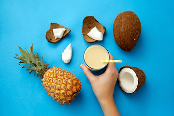 Image showing hand with pineapple coconut drink with paper straw