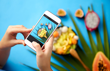 Image showing hands taking photo of exotic fruits on smartphone