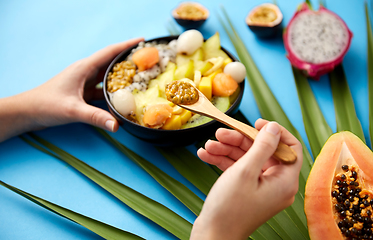 Image showing hands with mix of exotic fruits and wooden spoon