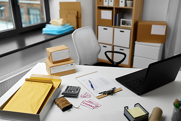 Image showing laptop and parcels on table at post office